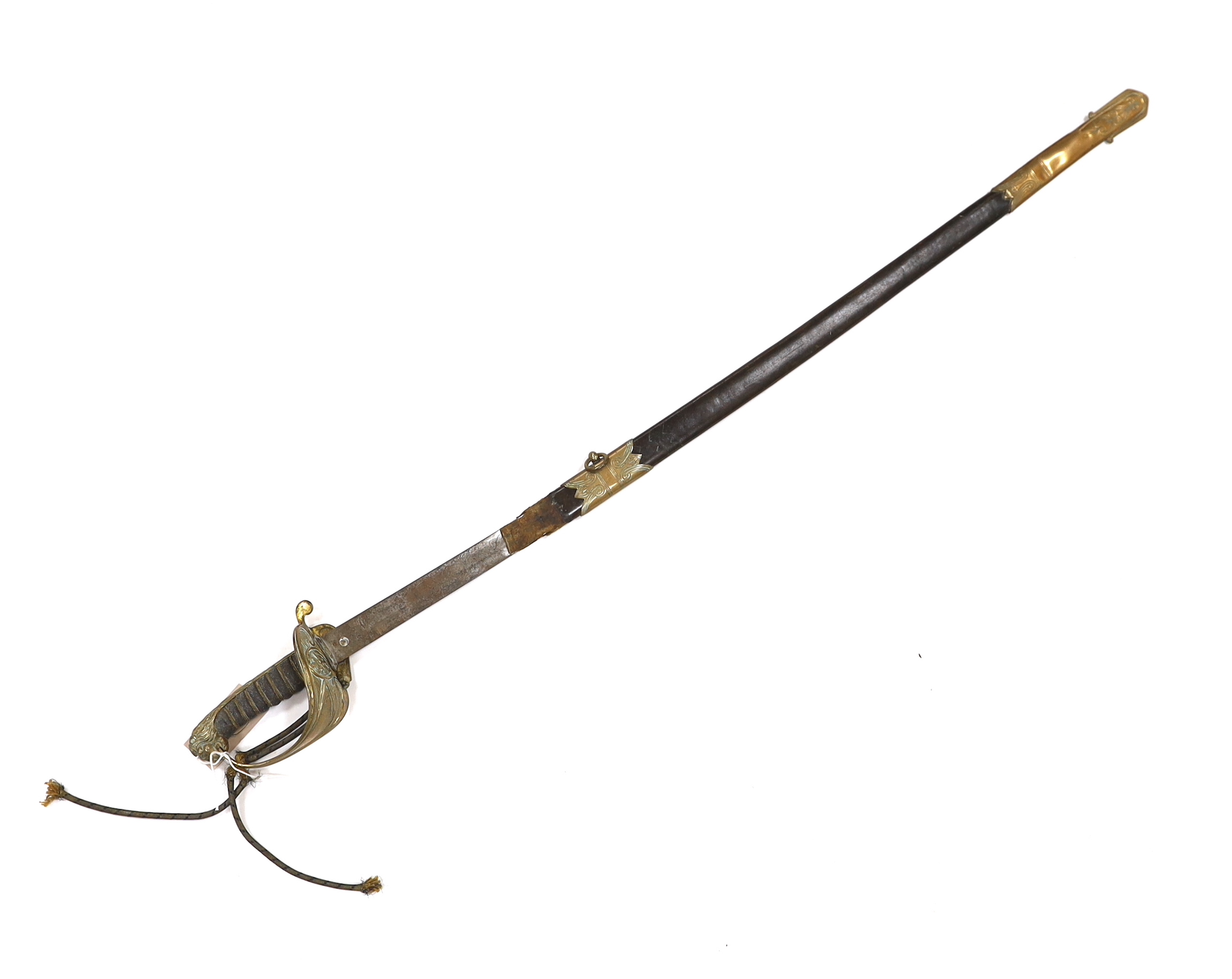 A late Victorian naval officer’s sword with regulation brass hilt, lion head pommel and blade etched with crown, VR and fouled anchor in its leather scabbard, top mount missing, blade 77cm